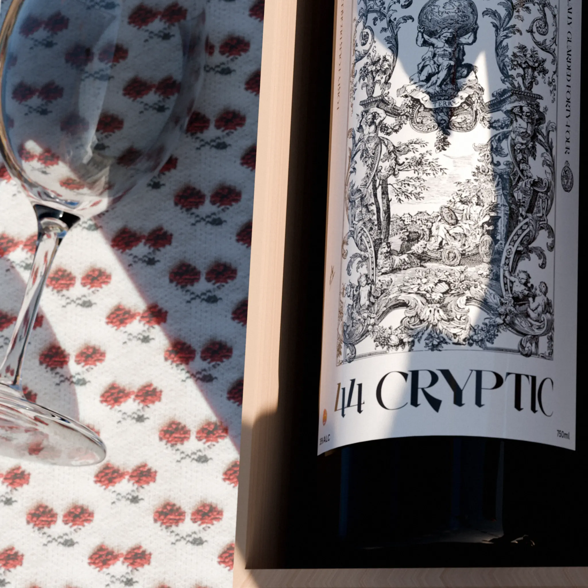 "Close-up detail of 44 Cryptic wine label showing intricate 1800s-style engraving artwork with patterned tablecloth reflection, highlighting luxury wine brand design